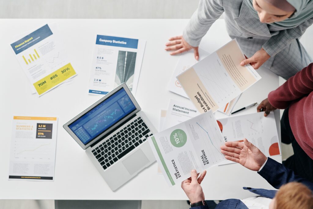 Vista superior de una reunión profesional con documentos, usada como imagen destacada para comunicación con vecinos.